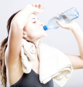 A woman drinking water after exercising