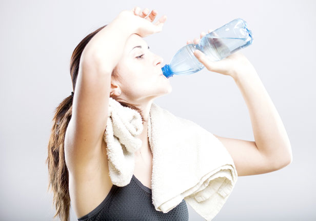 A woman drinking water after exercising