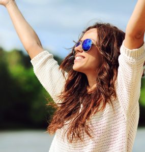 Happy wmoan outdoors with arms outstretched
