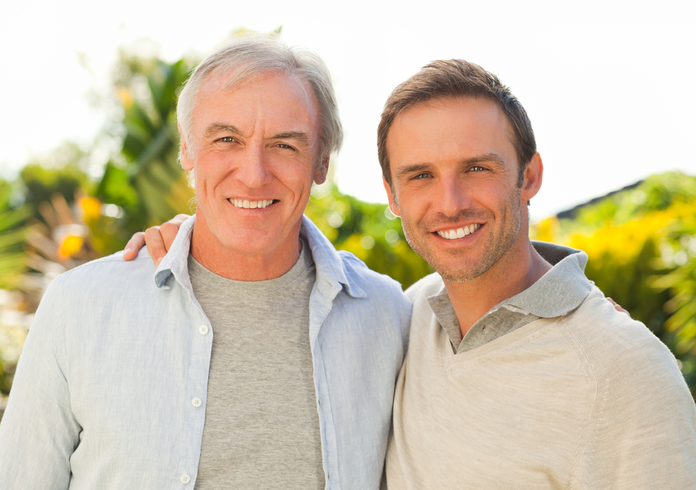  A middle-aged man and grown up son smiling