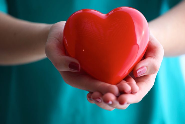 Close up of a woman holding a large red heart