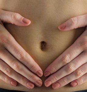 CLose up of hands on tummy to represent indigestion