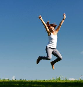 Woman jumping in the air on a spring day