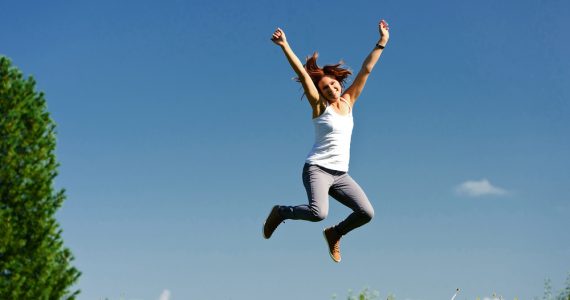 Woman jumping in the air on a spring day