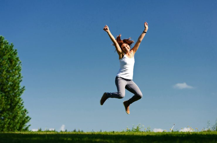 Woman jumping in the air on a spring day