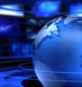A world globe and tv screens to represent news and current affairs
