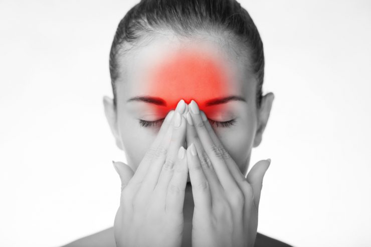 Woman in black and white with red highlighting over forehead to denote headache
