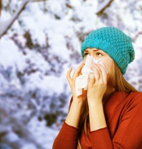 Woman in winter blowing her nose