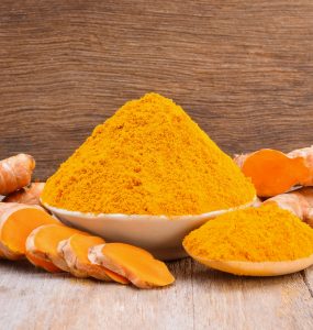 Turmeric root and a bowl of turmeric powder