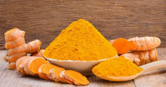 Turmeric root and a bowl of turmeric powder