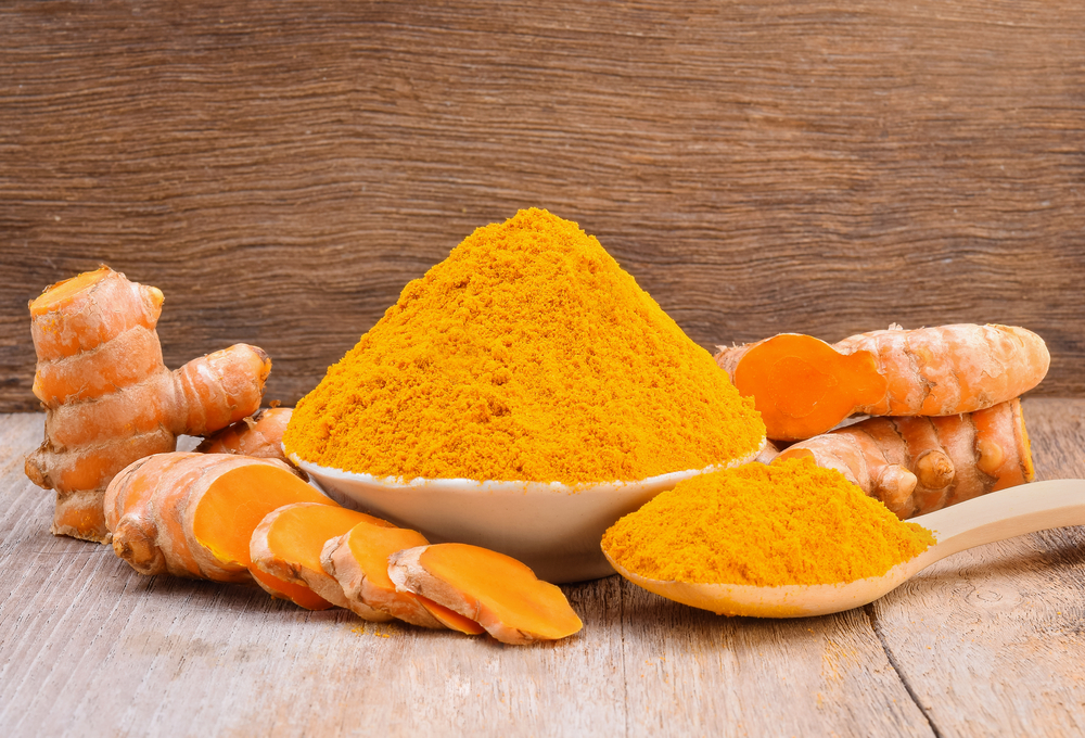 Turmeric root and a bowl of turmeric powder