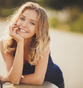 MIddle aged woman smiling at the camera with a riverside background