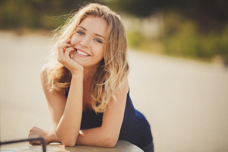 MIddle aged woman smiling at the camera with a riverside background