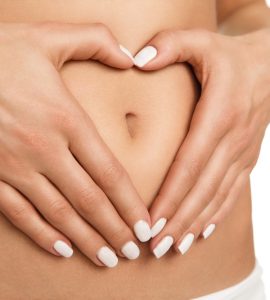 Close up on stomach with hands making a heart shape to show good digestion