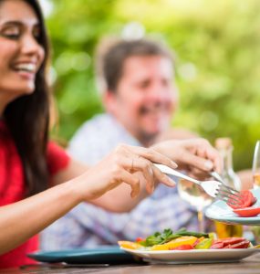 People enjoying eating outdoors representing summer nutrition