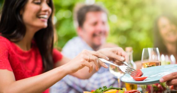 People enjoying eating outdoors representing summer nutrition