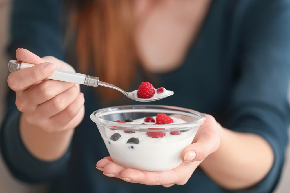 Close up of a woman wating yoghurt with fruit