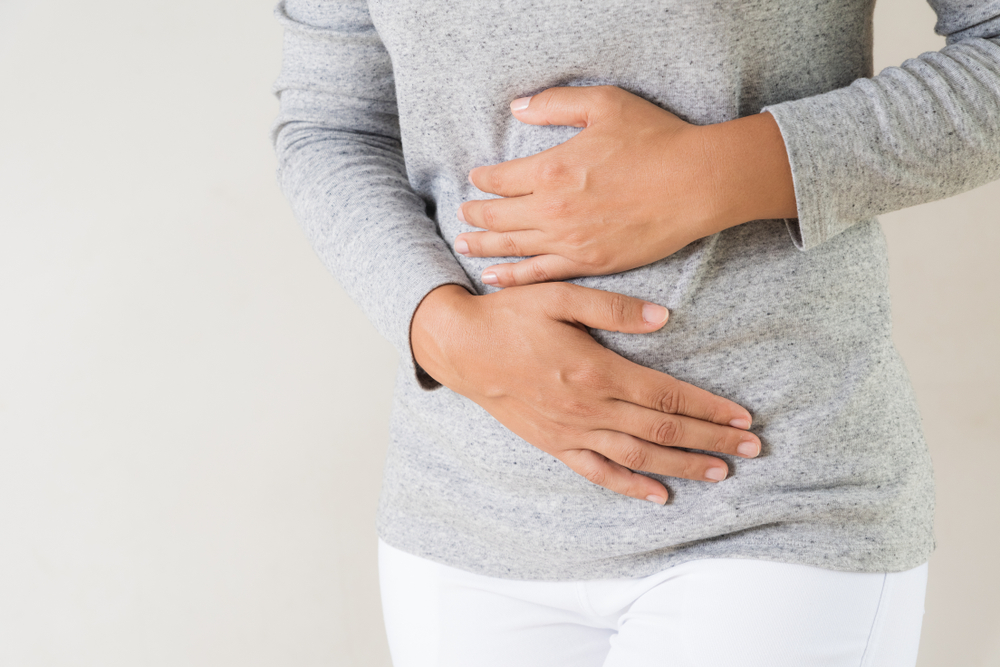 A woman holding her stomach experiencing bloating
