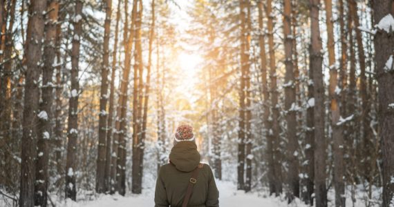 Woman taking a winter walk in snowy woodland