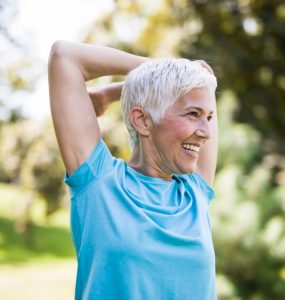Older woman stretching and exercising outdoors