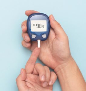 Close up of someone wiht diabetes using a blood sugar testing machine