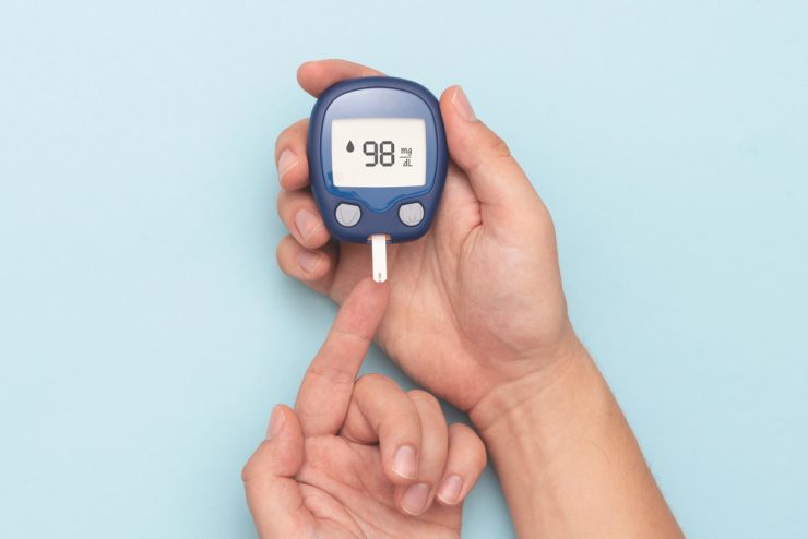 Close up of someone wiht diabetes using a blood sugar testing machine
