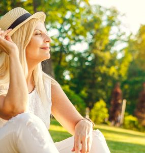 Middle aged woman enjoying the outdoors sitting in a park