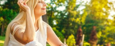 Middle aged woman enjoying the outdoors sitting in a park