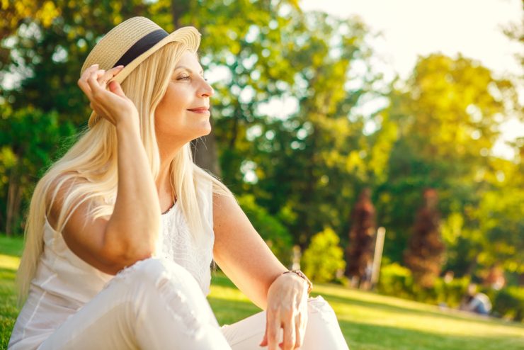 Middle aged woman enjoying the outdoors sitting in a park