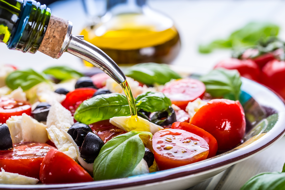 A salad of tomtatoes, olives, basil and mozarella to represent a mediterranean diet